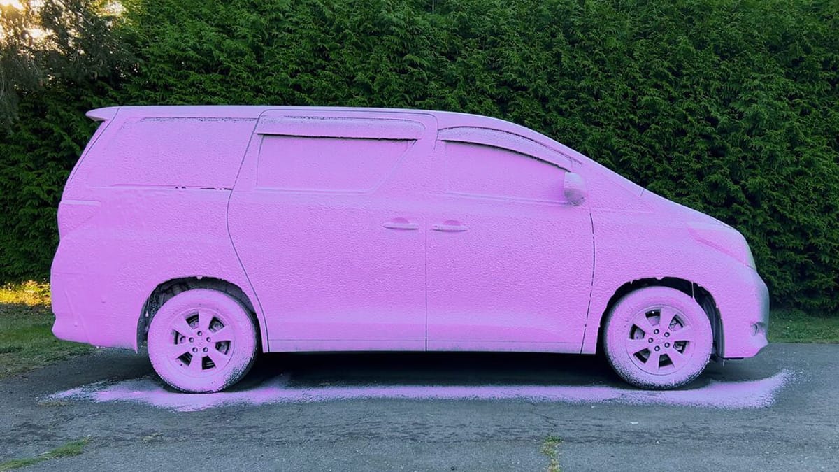 Minivan covered in pink wash foam